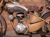 a old motorcycle that is parked in front of a brick wall