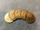 cinq pièces d'or empilées les unes sur les autres sur une table