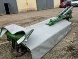 a tractor with a cover on it is parked in front of a building
