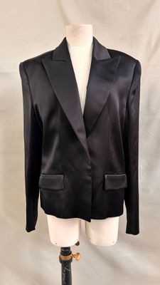 the jacket is black and has a gold buckle on the front