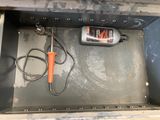 a bottle of liquid and a cord in a metal box