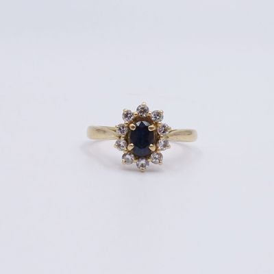 une bague en or jaune sertie d'un saphir bleu et de diamants blancs