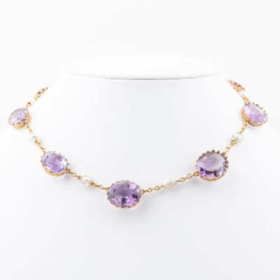 un collier orné de pierres violettes et de perles sur un mannequin blanc