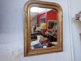 a mirror hanging on the wall next to a lamp