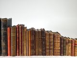 plusieurs vieux livres empilés sur une surface blanche