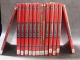 une pile de livres posée sur une table à côté d'une horloge