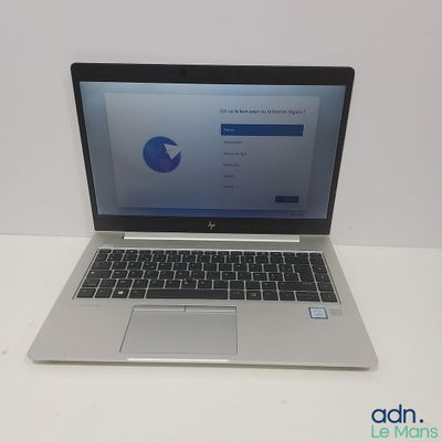 un ordinateur portable ouvert posé sur une table blanche
