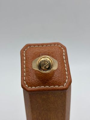brown leather box with a gold ring on top of it