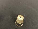 a pair of brass thimbles sitting on top of a black surface
