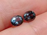 deux diamants bleus et violets posés sur le doigt d'une personne