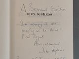 un livre ouvert, sur lequel est inscrit un poème manuscrit, posé sur une table