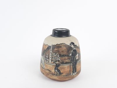 a small vase with a picture of a man and a woman