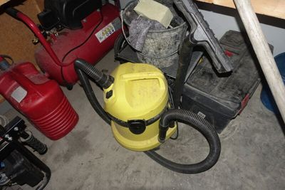 un aspirateur jaune et un seau jaune posés par terre