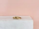 une bague en or posée sur un bloc de marbre blanc