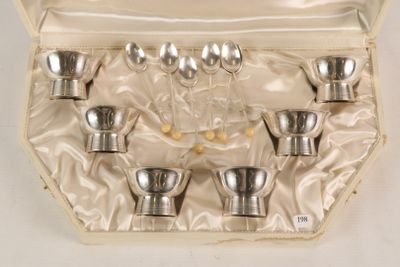 six silver spoons in a case on a white surface
