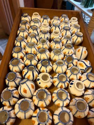 de nombreux petits vases blancs et bleus dans une boîte en bois