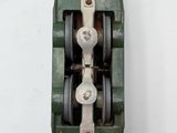 a green machine that is sitting on a white surface