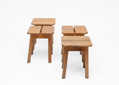 two small wooden stools sitting next to each other on a white surface