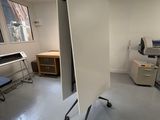 une photo d'une pièce avec un bureau, une chaise et une télévision