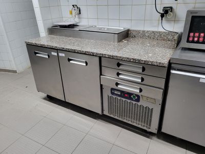 une cuisine équipée d'un évier et d'un micro-ondes posé sur le plan de travail