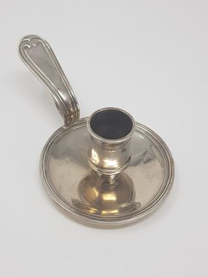 a silver saucer with a spoon on top of it