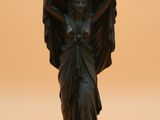 une statue représentant un ange tenant une horloge sur la tête