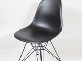 the chair is black and has a wire base and seat
