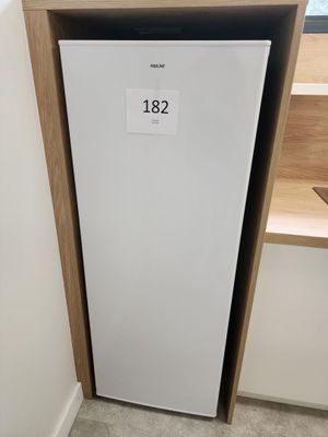 un petit réfrigérateur blanc dans le coin d'une pièce