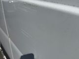 l'ombre d'une personne sur le flanc d'une camionnette blanche