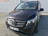 vue de face d'un monospace Mercedes noir garé devant un immeuble