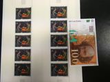 de nombreux timbres posés sur une table, avec la photo d'un homme