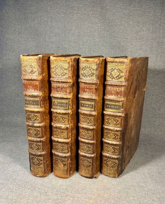 a set of four old books sitting on top of each other