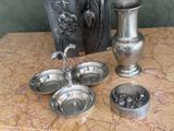 un vase en argent et d'autres objets en argent posés sur une table en marbre