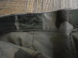 a close up of a camouflage pants on a wooden floor