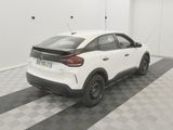 the rear end of a white car parked in a garage