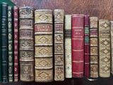many old books lined up on a shelf in a row