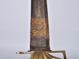 a gold sword that is on display on a table