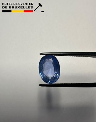 a close up of a blue sapphire being held by a pliers