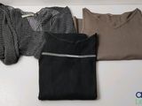 three sweaters are lined up on a table with a sweater on top of them