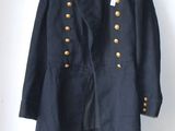 an old military jacket hanging on a wall next to a wooden hanger