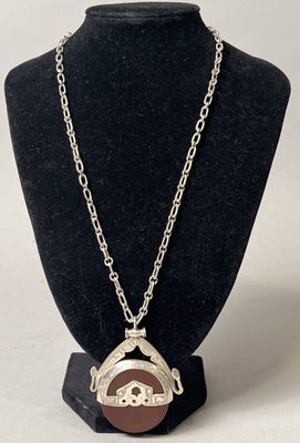 collier en métal argenté avec un pendentif en émail marron et blanc