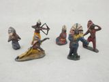 Plusieurs figurines représentant des Amérindiens sont disposées sur une surface blanche.