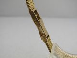 a close up of a gold watch on a clear stand