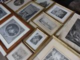 a lot of framed pictures on a table in a room