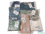 several pairs of men ' s shirts in plastic bags on a white surface