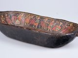 an old wooden bowl with a painted design on it