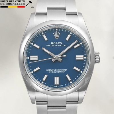 Les cadrans bleus d'une montre Rolex se détachent sur un fond blanc.