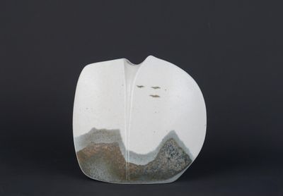 un vase blanc orné d'un motif de montagne