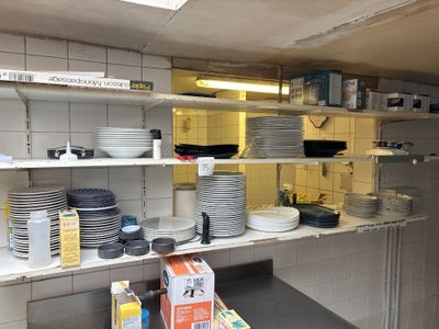 beaucoup d'assiettes et de casseroles sur les étagères de la cuisine