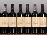 bottles of wine are lined up on a shelf in a row
